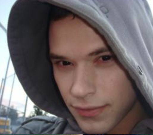 a young man wearing a hoodie looking at the camera