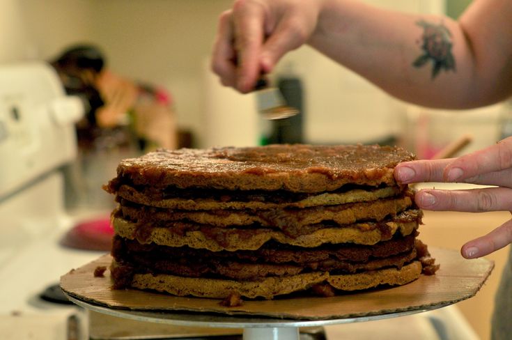 a person is cutting into a stack of pancakes