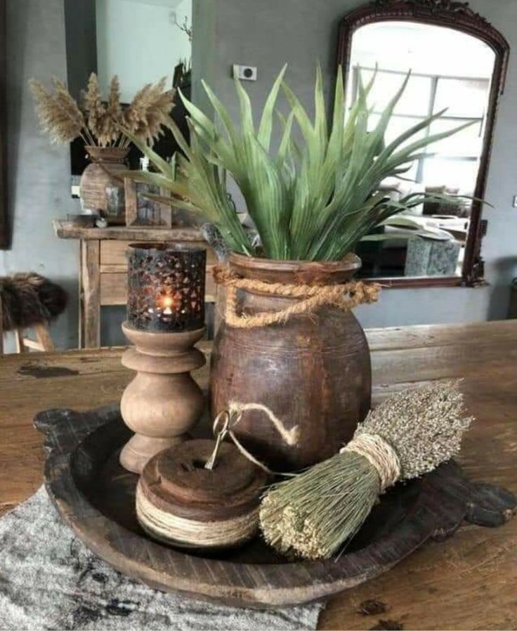 a potted plant sitting on top of a wooden table next to a candle holder