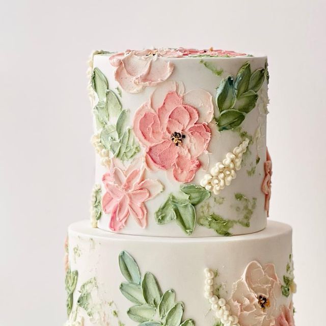 a three tiered cake decorated with flowers and leaves