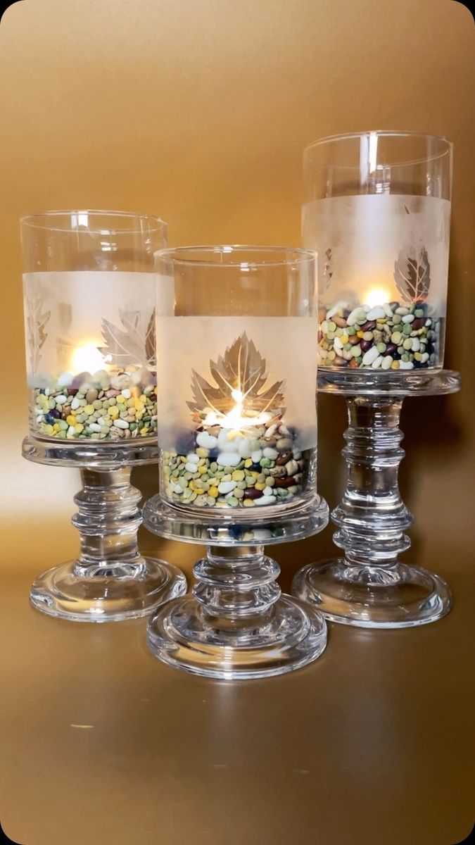 three glass candles are sitting on a table