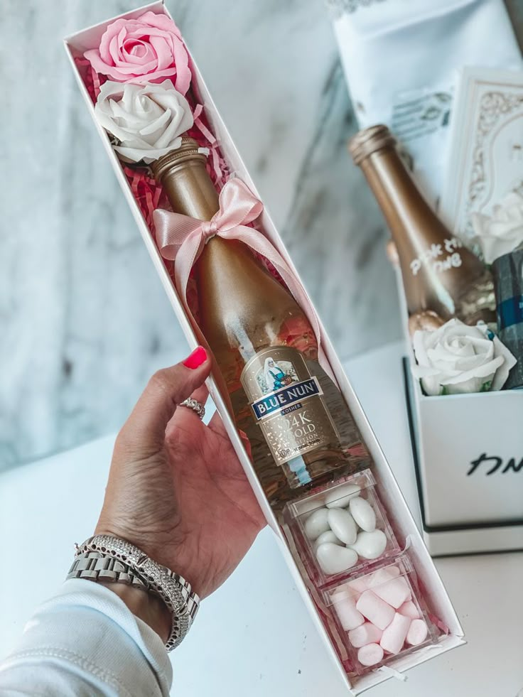 a person holding a bottle of champagne and marshmallows