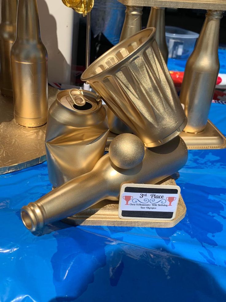 a metal object sitting on top of a blue table covered in shiny gold colored paint