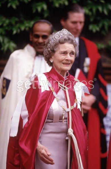 an older woman in a red and white gown with a tiara on her head