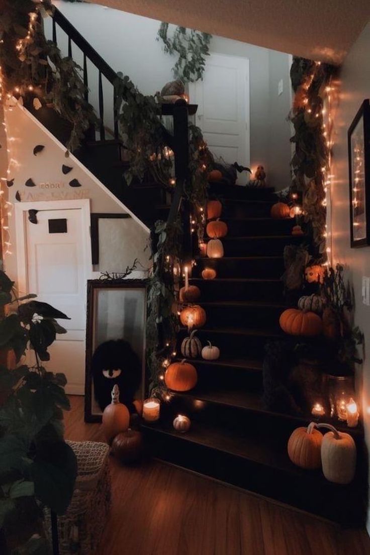 the stairs are decorated with pumpkins and greenery