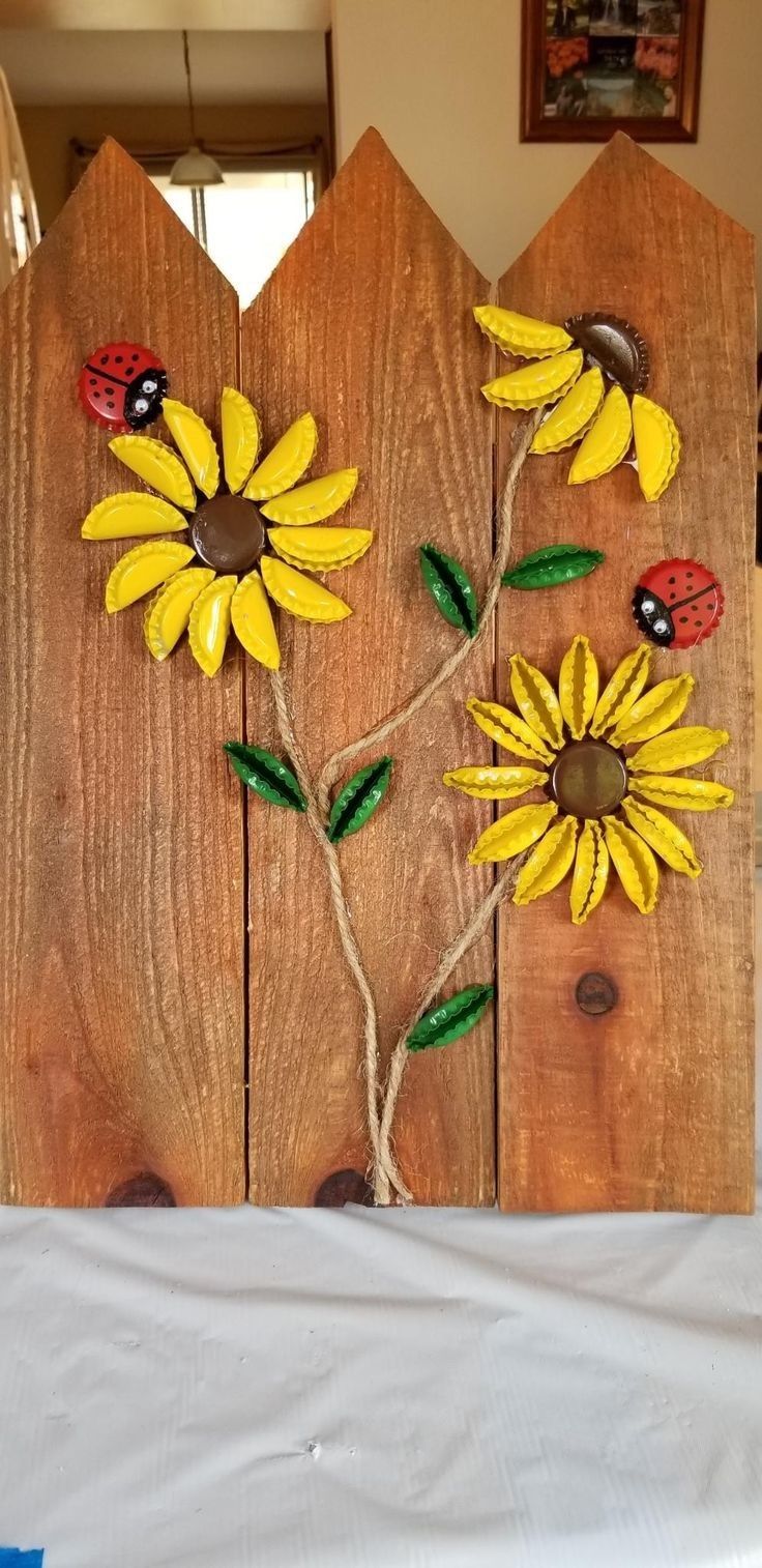 a wooden fence with sunflowers and ladybugs painted on it