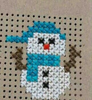 a cross stitch pattern with a blue and white snowman