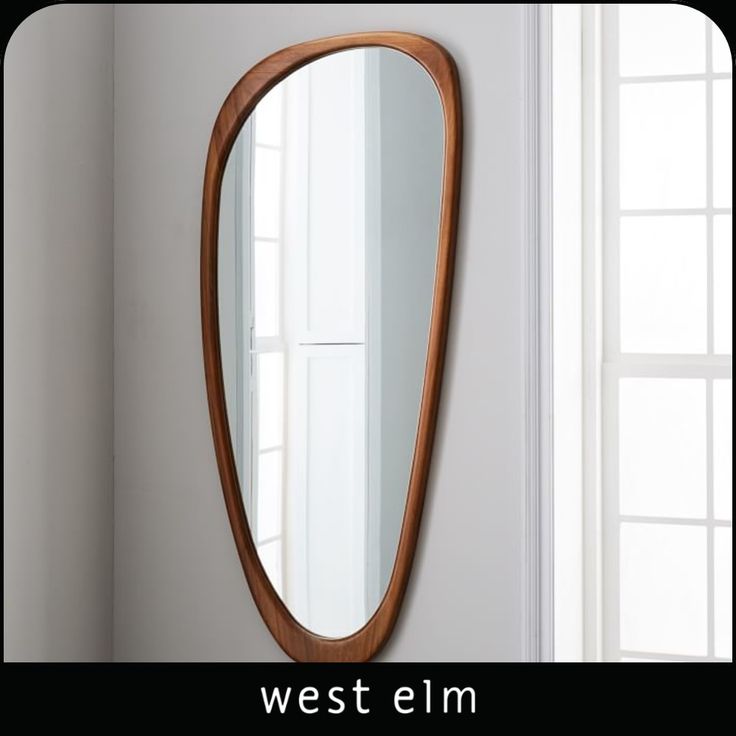 a mirror hanging on the wall next to a sink in a room with white walls