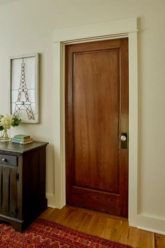 a room with a wooden door and rug on the floor