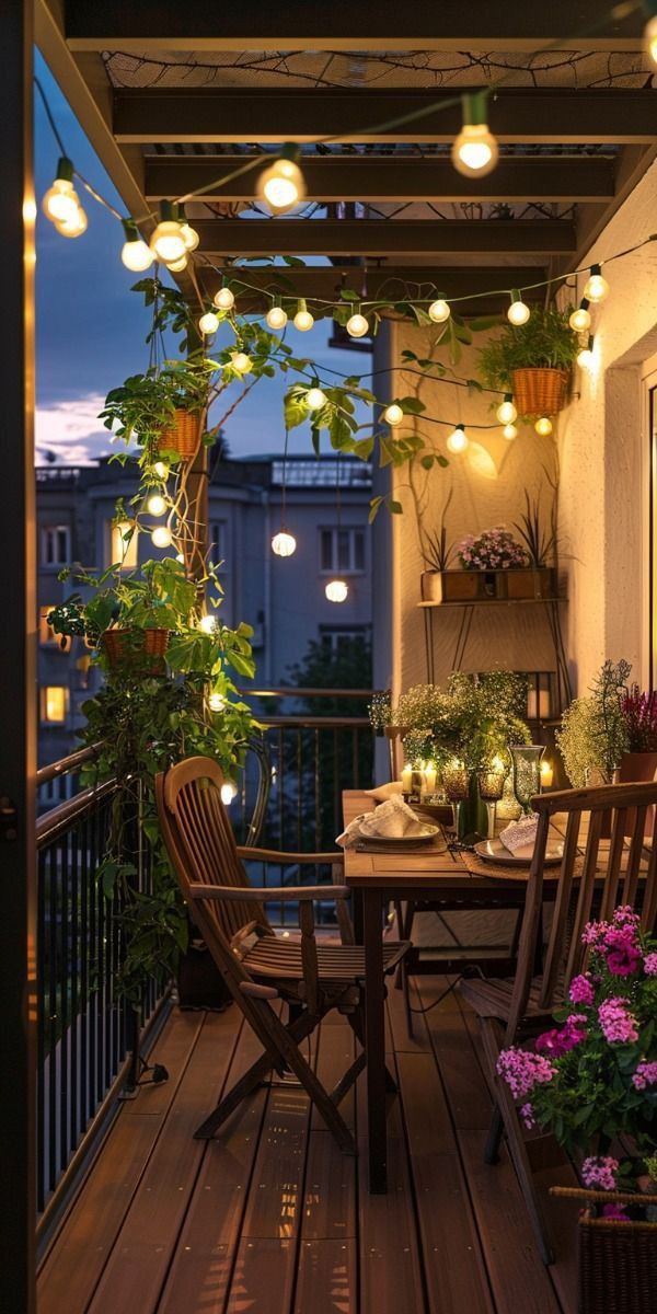 an outdoor dining area with lights strung from the ceiling and potted plants on the balcony