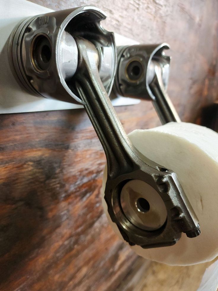 a close up of a toilet paper roller on a wooden wall with a metal handle