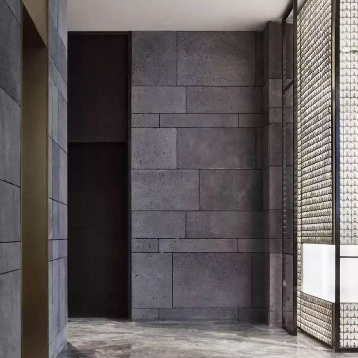 an empty bathroom with stone walls and flooring is seen in this image from the inside