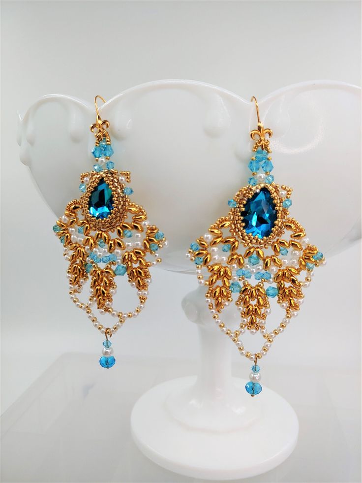 Introducing my exquisite Victorian chandelier earrings, a true masterpiece of elegance and sophistication. These stunning earrings are the perfect accessory for a variety of occasions, whether it's a bridal event, an evening out, a mother-of-the-bride affair, a special celebration, a wedding, a prom night, or a glamorous pageant. Prepare to be mesmerized by the enchanting sparkle of these earrings. The tear-drop crystals boast a deep, rich color that seems to extend into infinity, casting a radi Bridal Chandelier Earrings, Victorian Chandelier, Turquoise Chandelier, Statement Chandelier, Pearl Earrings Handmade, Bridal Earrings Chandelier, Wedding Accessory, Turquoise Crystal, Sparkly Earrings