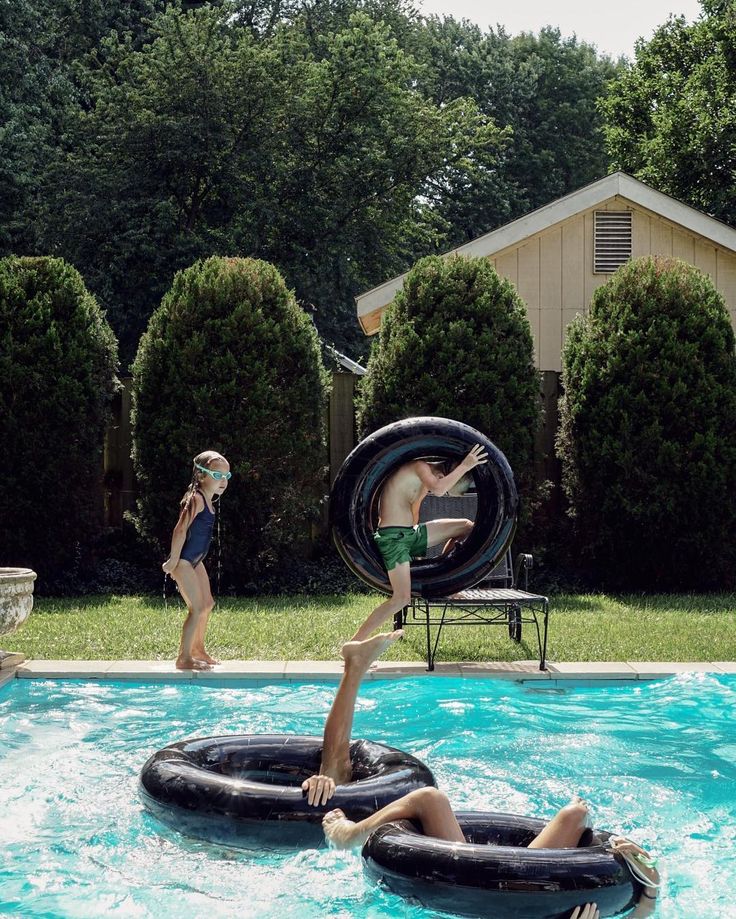 two people are playing in an inflatable pool while another person watches from the side