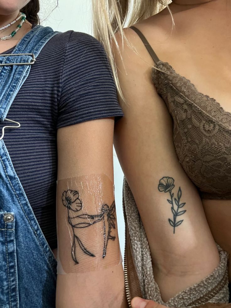 two women with tattoos on their arms