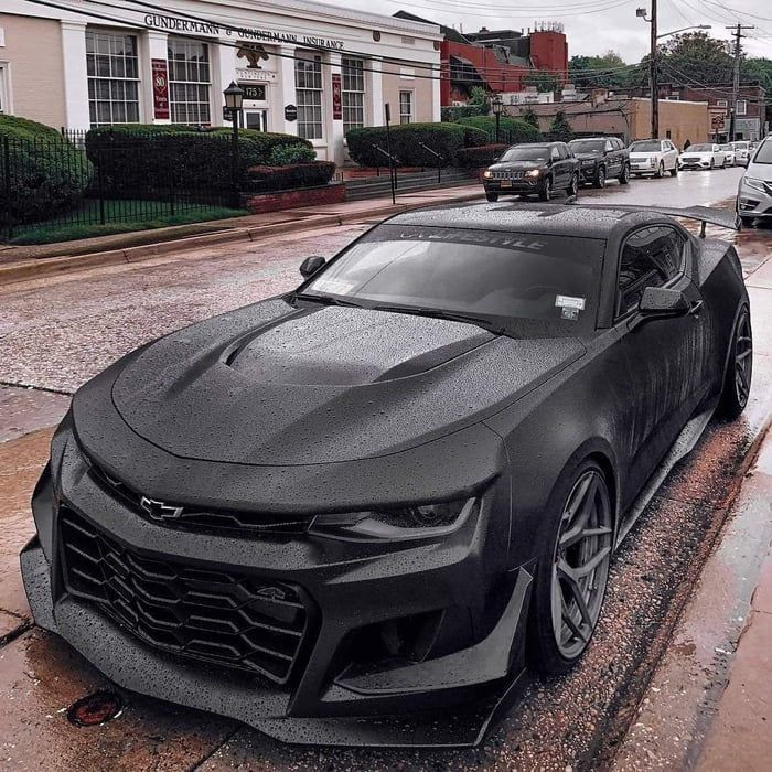 a black chevrolet camaro is parked on the street