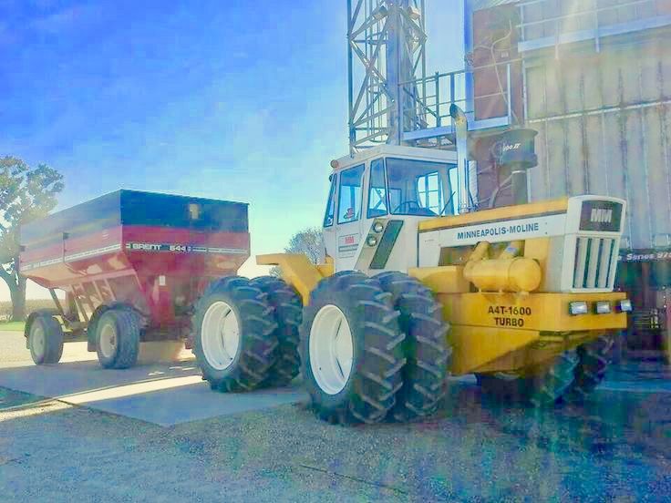 there is a large tractor next to a truck