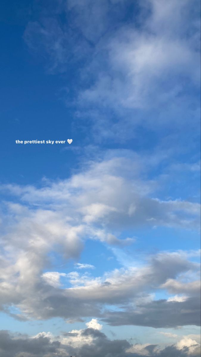 an airplane is flying in the sky with some clouds above it and another plane on the ground