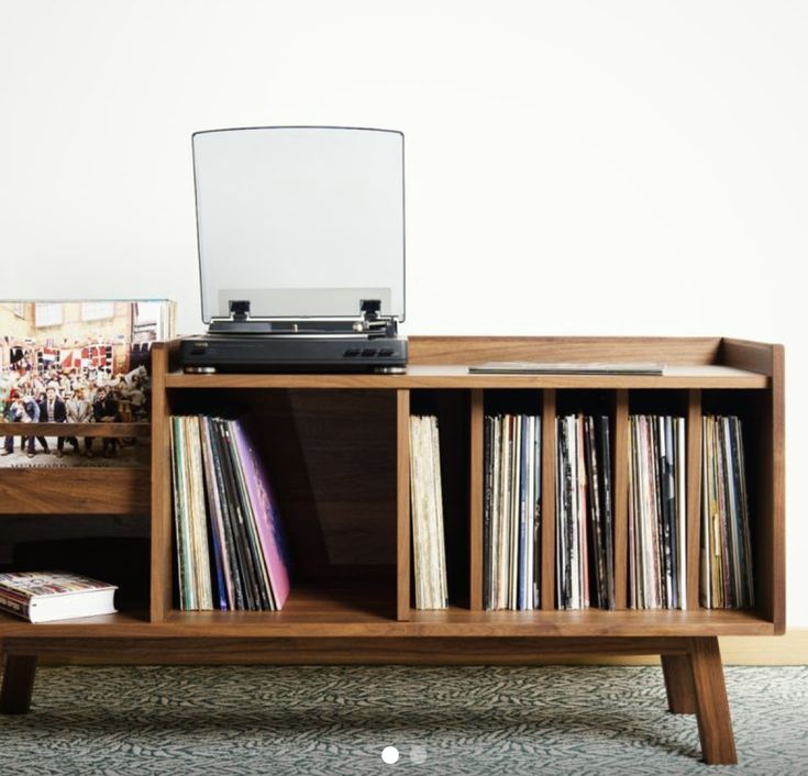 a record player sitting on top of a wooden shelf