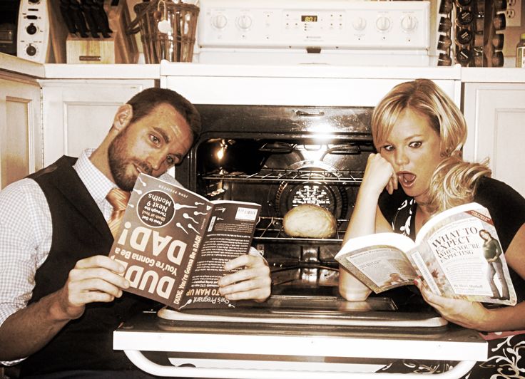 a man and woman looking at cookbooks in an oven