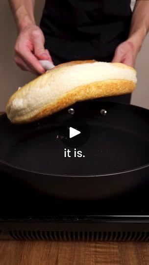 a person holding a loaf of bread on top of a frying pan that says it is