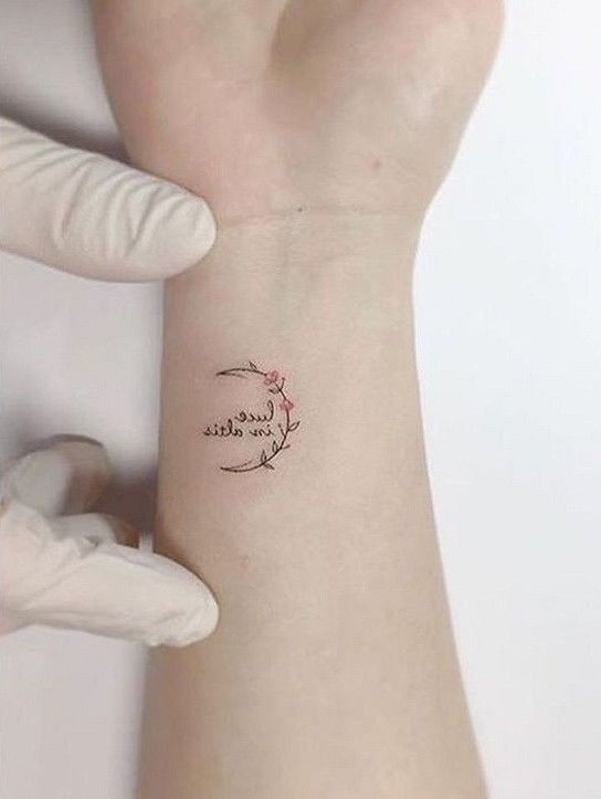 a woman's arm with a small tattoo on it