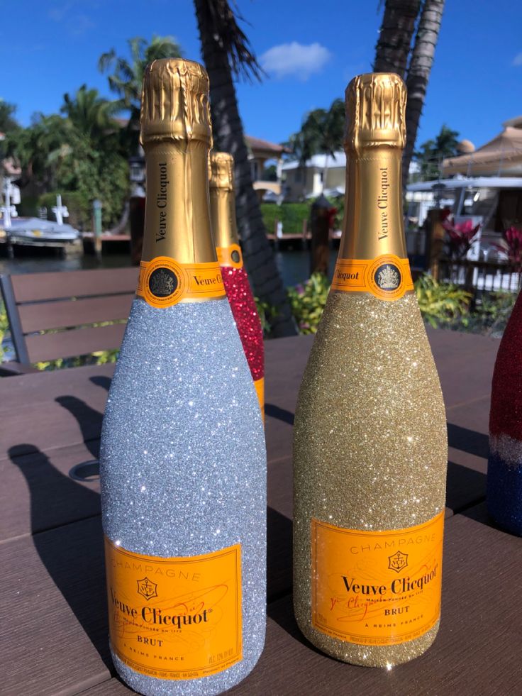 two bottles of champagne sitting on top of a wooden table next to eachother