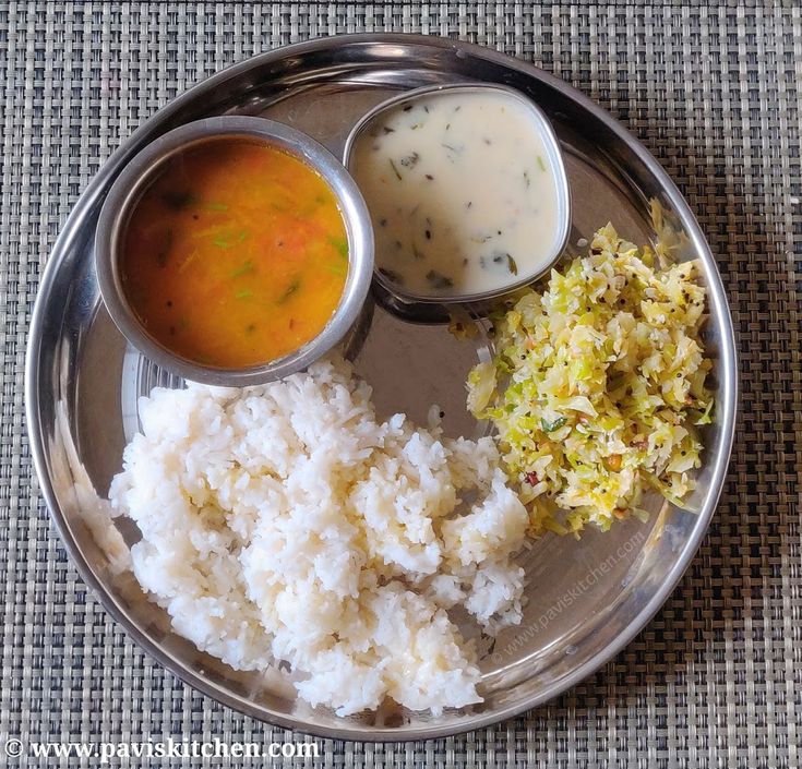 a silver plate topped with rice and sauces