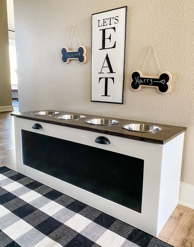 a black and white dog food station with three bowls