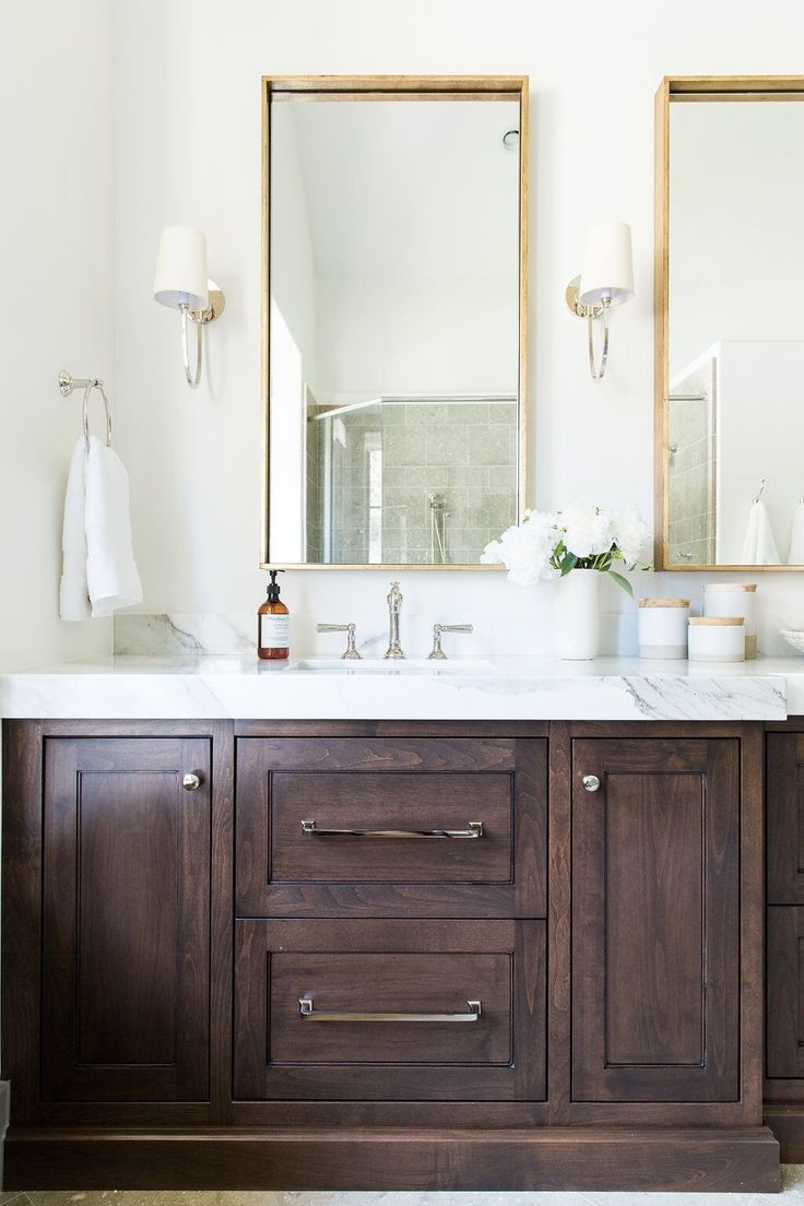 a bathroom vanity with two mirrors above it