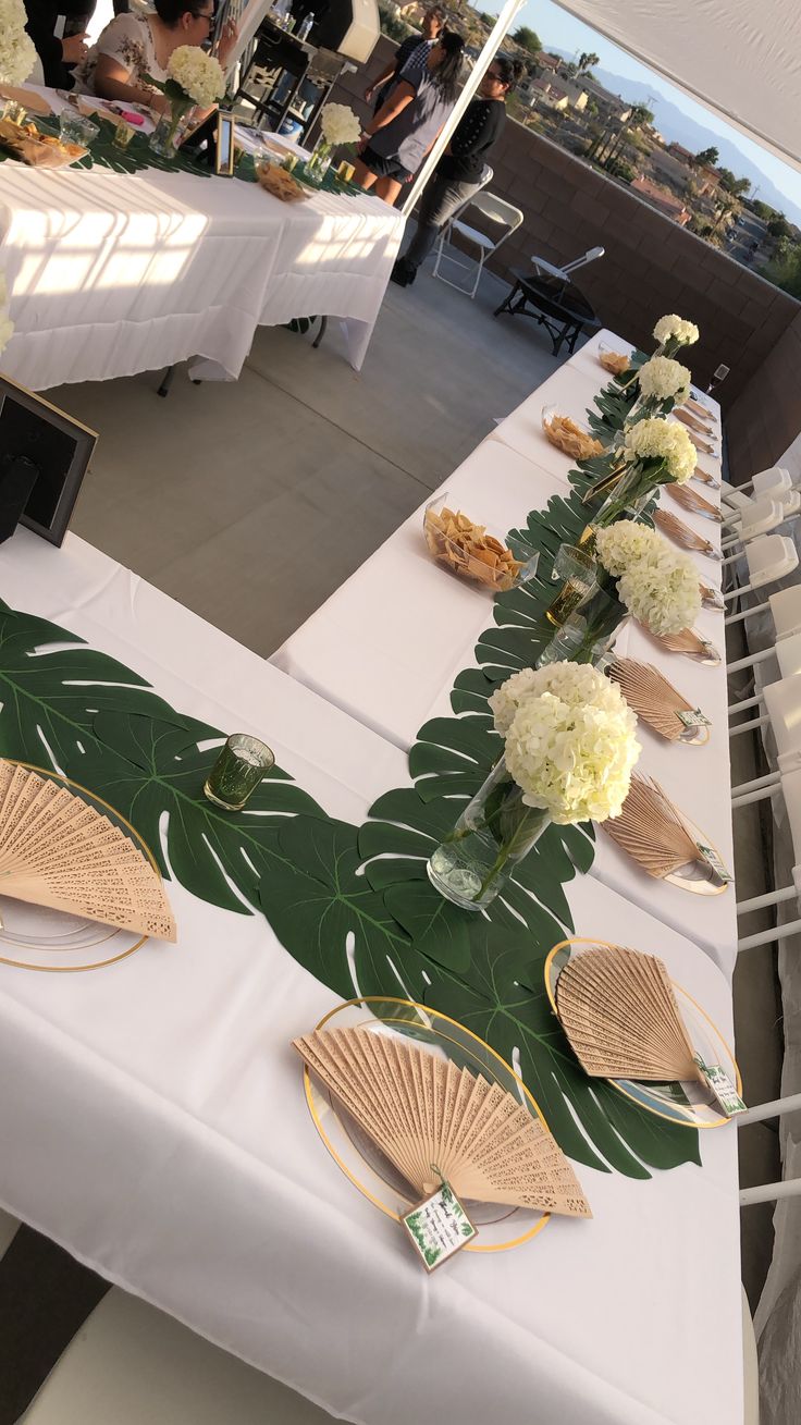 a long table with flowers and plates on it