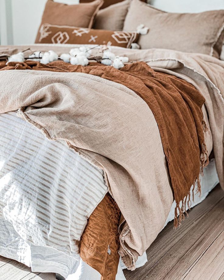 a bed covered in brown and white blankets