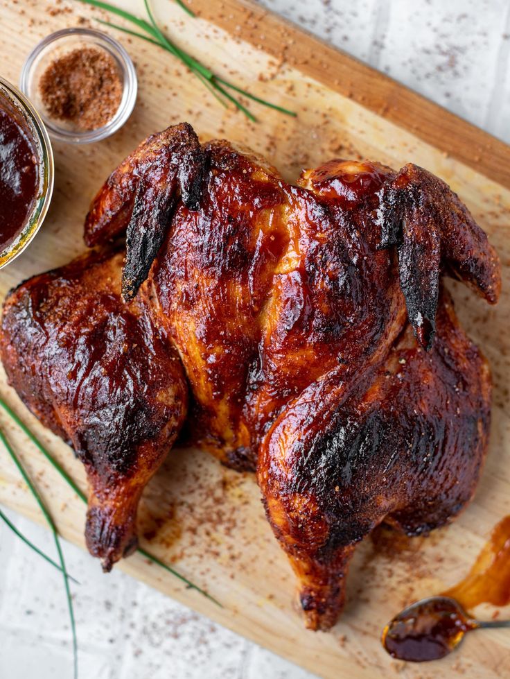 a close up of a chicken on a cutting board with ketchup and seasoning