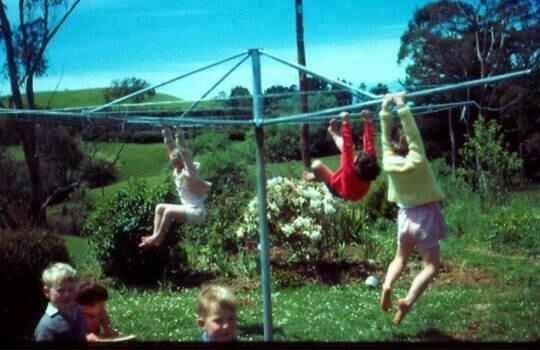 three children are playing with a net in the yard