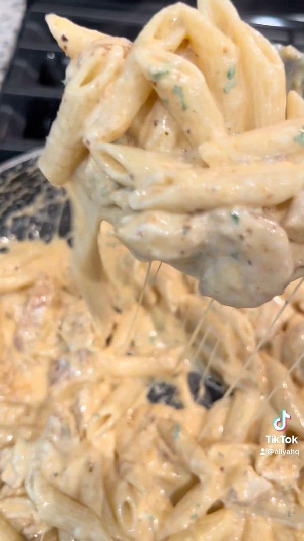 a pasta dish is being stirred with a ladle to make it look like chicken parmesan