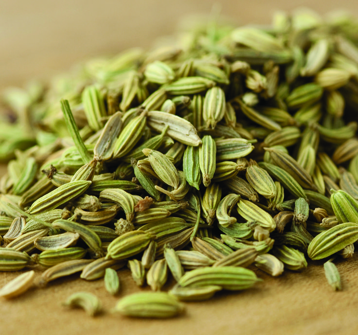 a pile of green seeds sitting on top of a wooden table next to each other