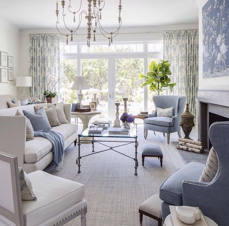 a living room filled with lots of furniture and a chandelier hanging from the ceiling