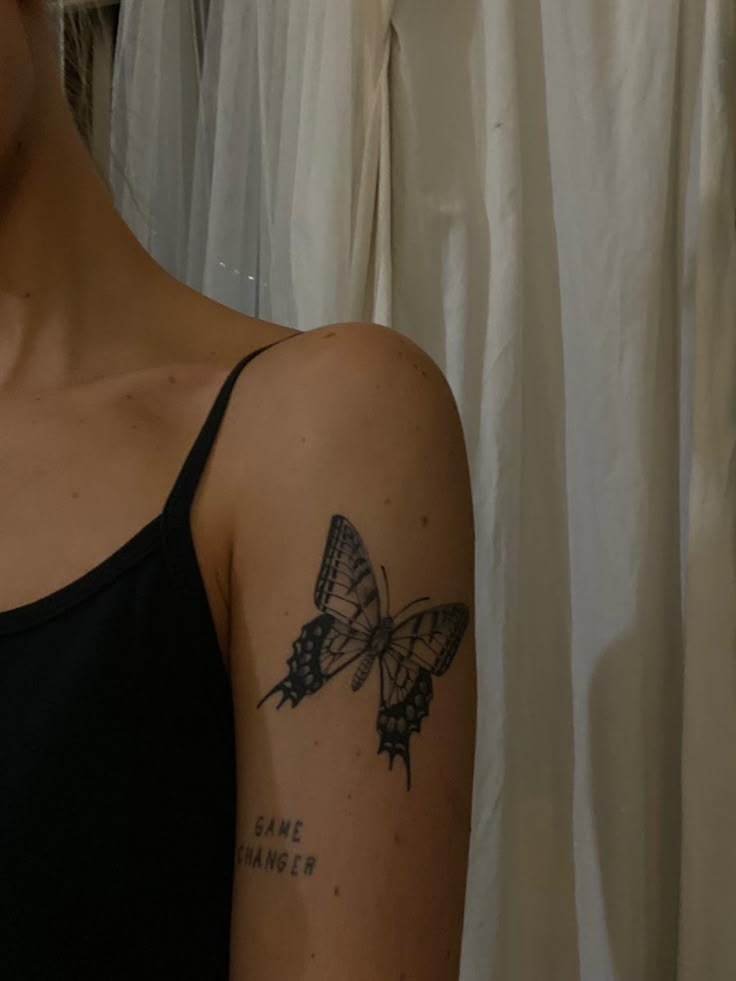 a woman's arm with a butterfly tattoo on the left side of her arm