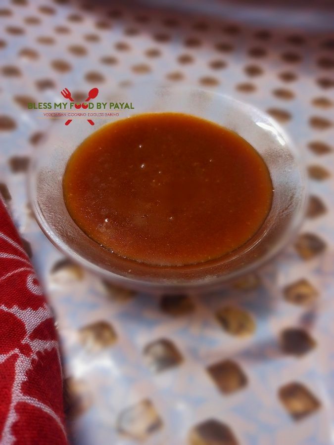 a small bowl filled with sauce sitting on top of a white and red table cloth