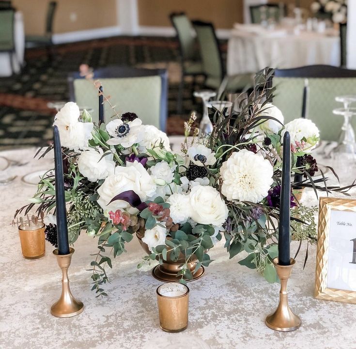 the centerpieces are decorated with white flowers and greenery, along with candles