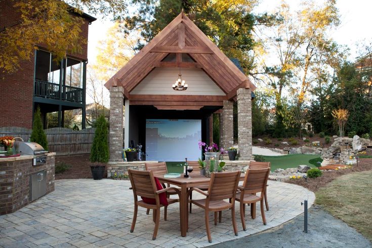 an outdoor patio with table and chairs next to a fire pit in the back yard