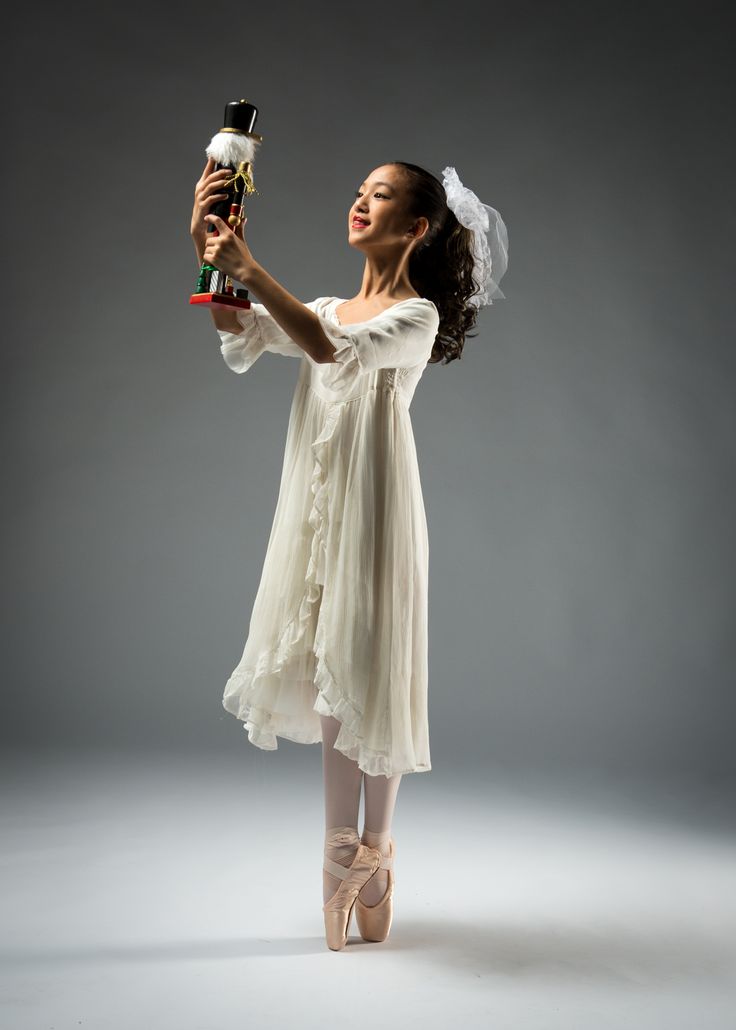 a woman in a white dress holding a bottle