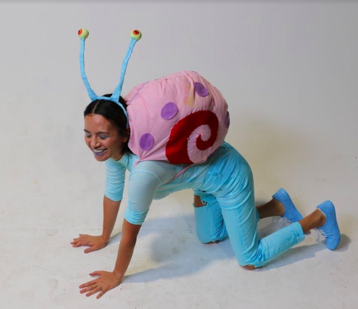 a woman in blue pants and pink shirt on the ground