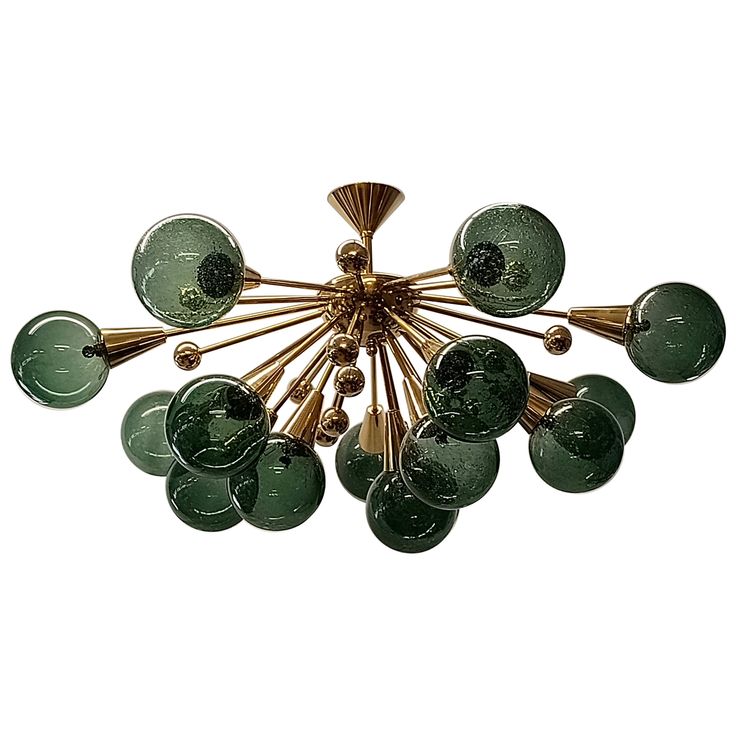 a chandelier with green glass shades and gold metal fixtures on the bottom half