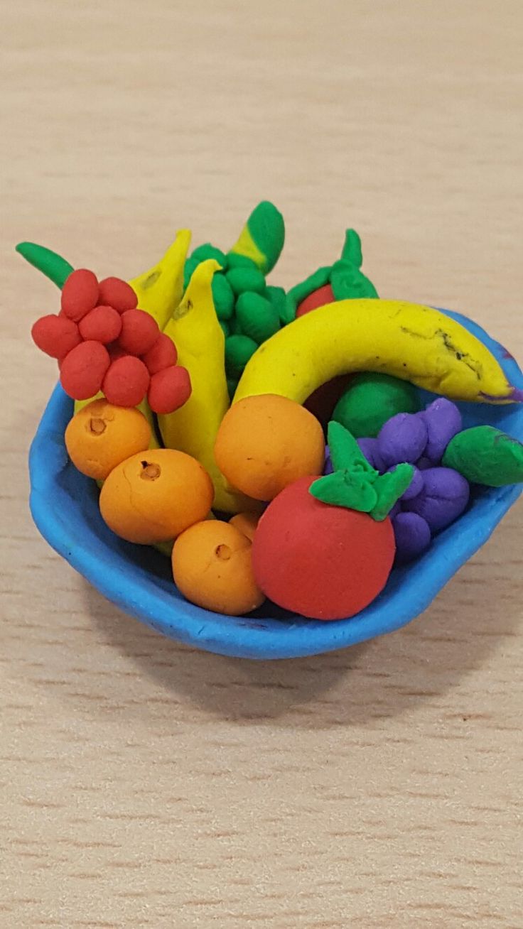 a blue bowl filled with fruit sitting on top of a wooden table next to a banana