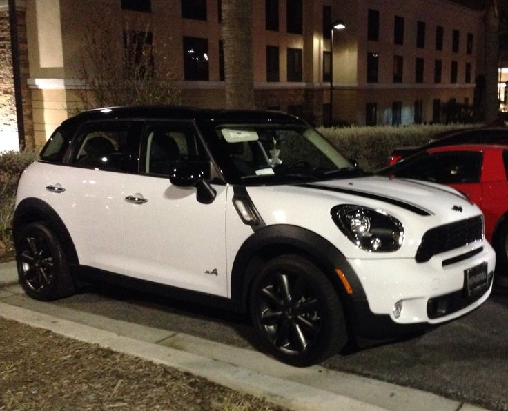 two cars are parked on the side of the road at night in front of a building