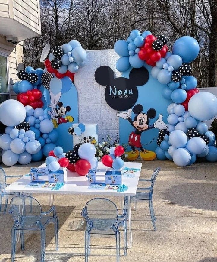 a mickey mouse birthday party with balloons and decorations