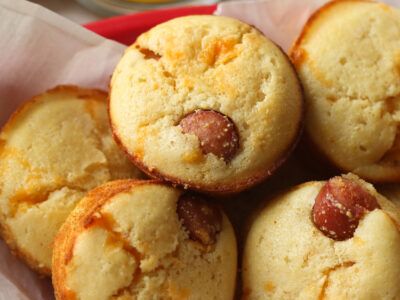 a red basket filled with small pastries on top of paper