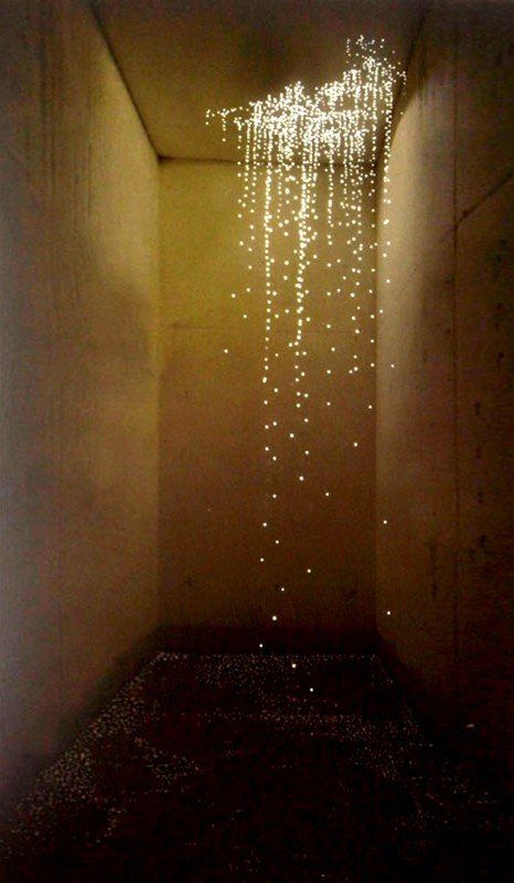 an empty hallway with some lights hanging from it's ceiling and on the wall