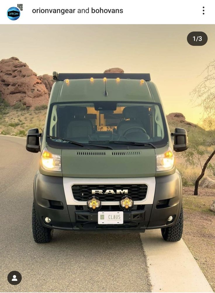 a green van parked on the side of a road next to a desert area with rocks and trees